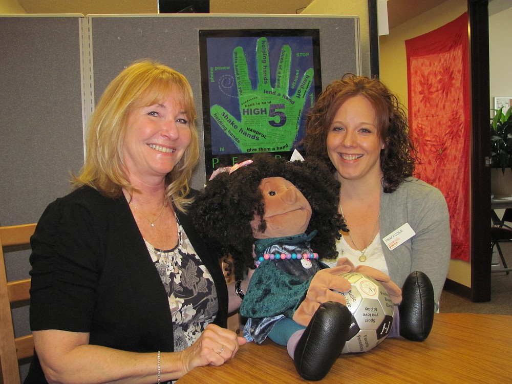 Volunteer Karen Hamilton (left) works with family advocate Traci Cole and puppet "Rosie" at an outreach program for second-grade students at Fruit Valley Elementary School in Vancouver.