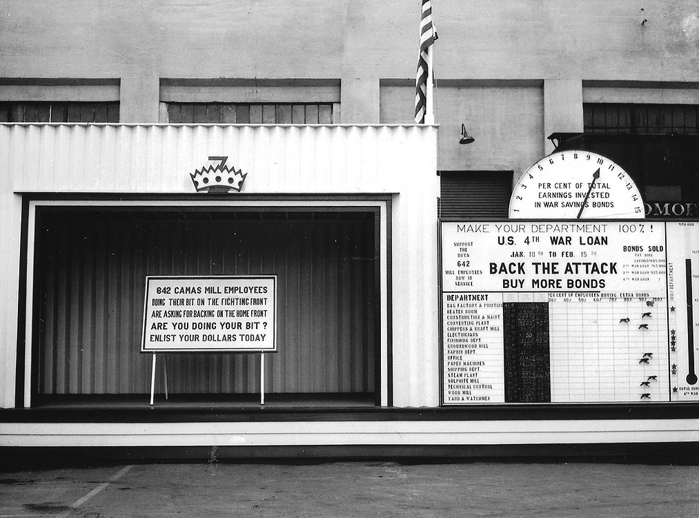 A sign in front of the Camas paper mill during World War II encourages employees to "Back the Attack Buy More Bonds." War bonds, known as debt securities, financed  military operations during war time. They were seen as a way to remove money from circulation as well as reduce inflation.