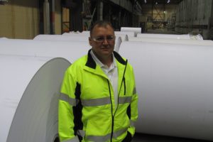Joe Ertolacci, the new manager of the Georgia-Pacific mill, in Camas, stands next to communication paper rolls in the number 20 building. He has worked in the paper industry for 24 years.