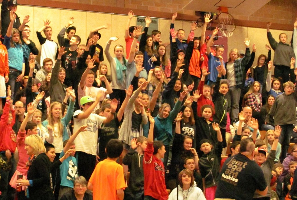 Students at Jemtegaard Middle School eagerly raise their hands to donate $1 for the opportunity to help duct tape teachers Anna Linde and Ron Schlauch to the gym wall.