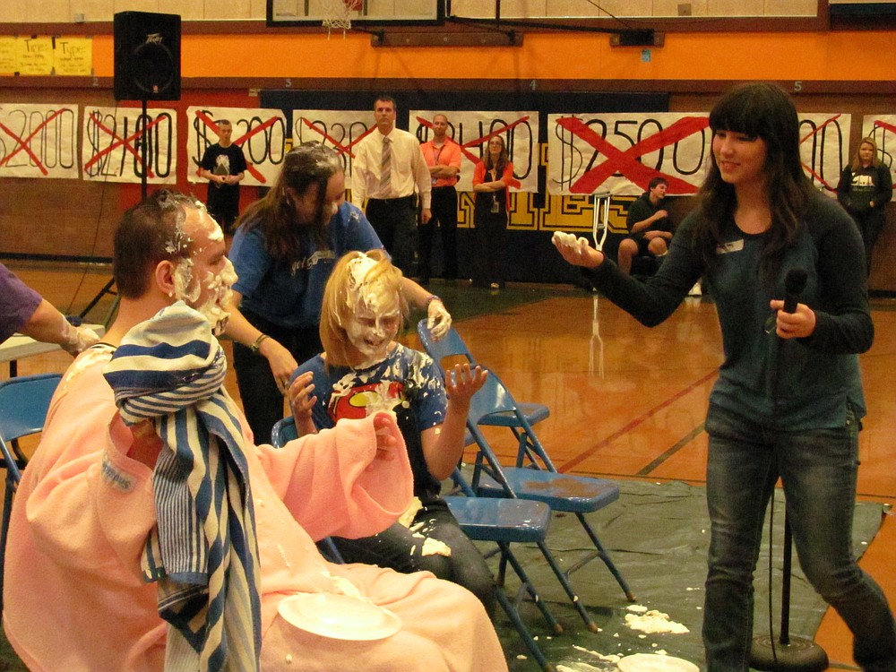 Seventh-grader Imagen Huey throws a whipped cream "pie" at science teacher Glenn Rhodes during the assembly.  Behind her are eighth-graders Kayla Radford and Brooke Hinson.