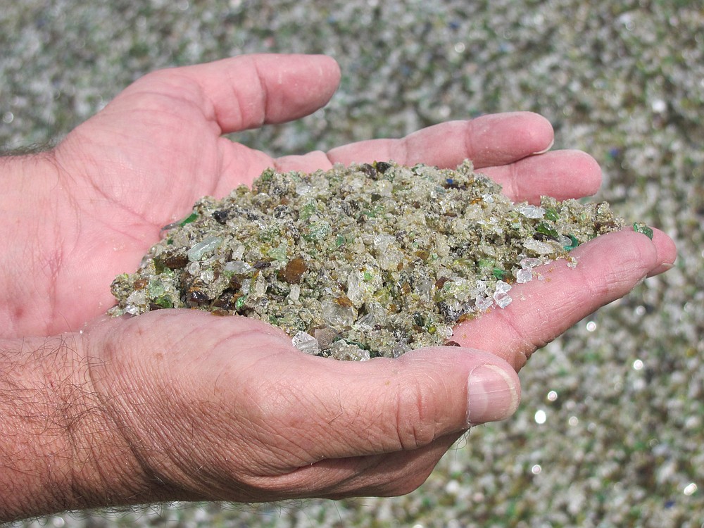Chris Nottenkamper, assistant district manager for Waste Connections, holds a handful of recycled glass. Some of the material was used in the construction of the Salmon Creek interchange in Vancouver.