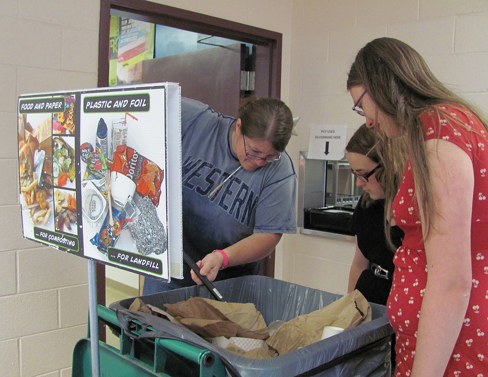 Skyridge Middle School technology teacher Ann Hofmann, and Green Team members (left to right) Sidney Greenamyer and Kaelene Barlow regularly sort through recycling and garbage bins during lunchtime, and remove items that are put in the wrong area.