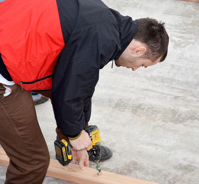 James Heberling drills a hole into a two-by-four board while he and other CWU students built the house.