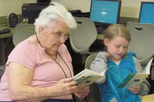 Volunteer Marilyn Adler listens to second-grader Trinity Archer read her a story. Adler is one of several volunteers from Columbia Ridge Senior Living who reads with students on a weekly basis. "It's nice to be around the kids and work with them," the retired teacher said.