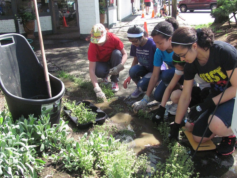 From right to left, Nkem Day, Claire Martin-Tellis, Hana Rabbani and Marilyn Boerke weed flower beds in downtown Camas during the Earth Day beautification project Sunday.