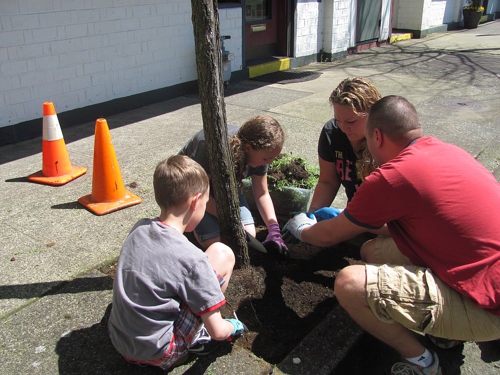 Shane Woodward, co-owner of Bead Paradise in downtown Camas, brought his wife, Desiree, and children Zach and Morgan out to help him during the DCA Earth Day beautification project Sunday.
