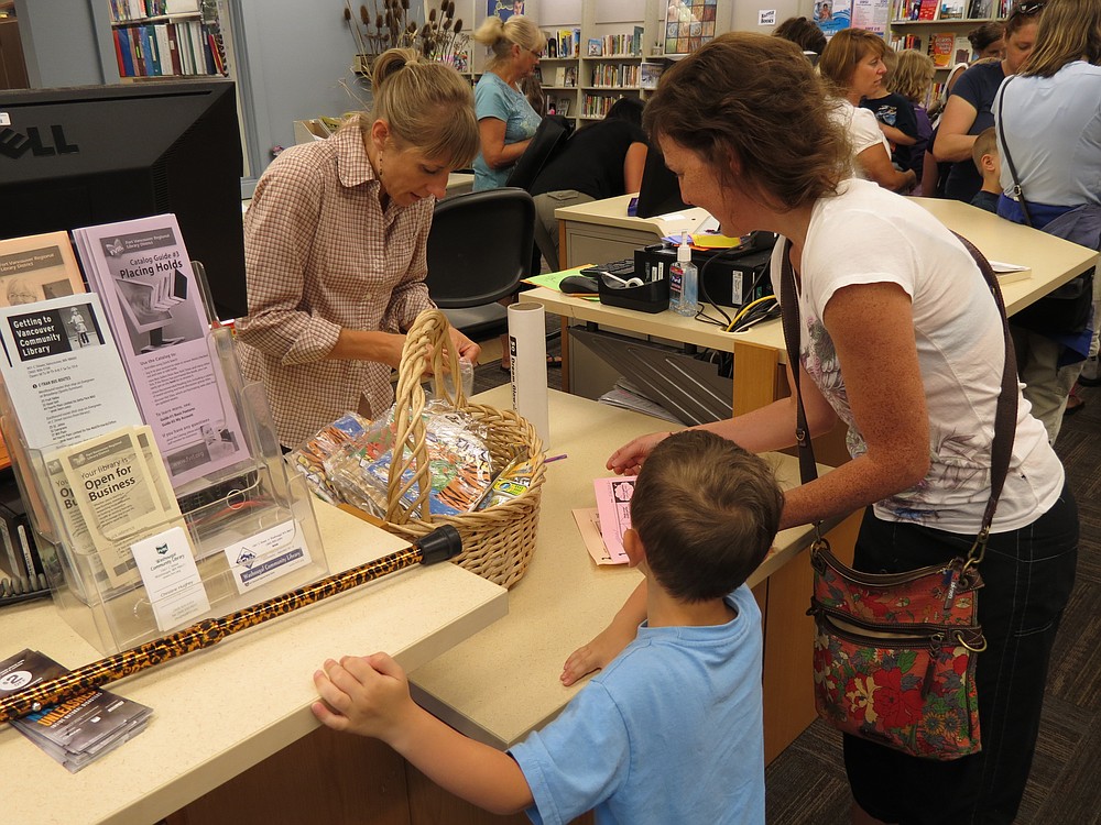 A summer reading program participant eagerly selects a prize at the Washougal Community Library. Local reading programs are one of many activities offered during the summer months.