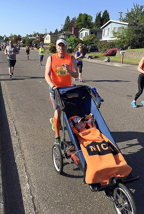 Micah and Jeff Snell pass mile 17 at the Tacoma Marathon on May 3. It was the third of five marathons the two have participated in to raise money for different charities.