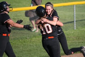 Kayla Lagerquist (left) and Abby Young (right) pounce on Madisen Baldwin after she drove in the tying and winning runs for Washougal in the bottom of the seventh inning. The Panthers beat Mark Morris 5-4 Monday, to get to the district tournament for the first time since 2004.