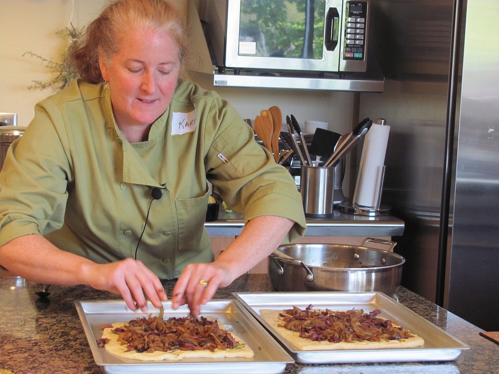 Lasher puts caramelized onions on top of pizza dough. She refers to the onions as "caramelized gold," saying, "They make everything taste better."