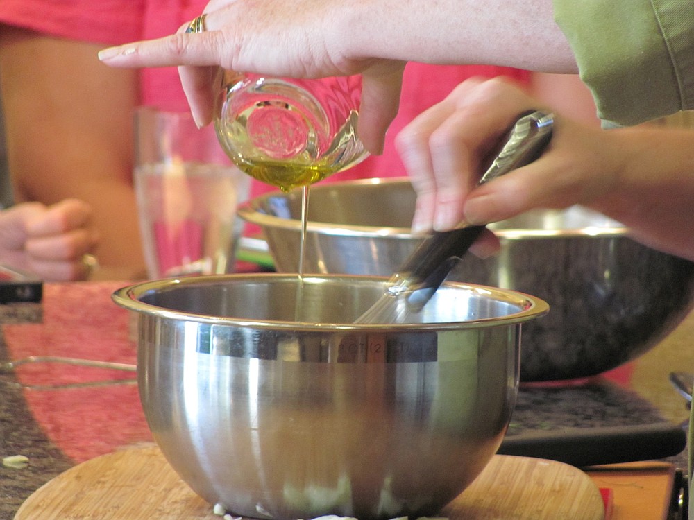 Lasher demonstrates the proper technique for mixing olive oil into salad dressing.