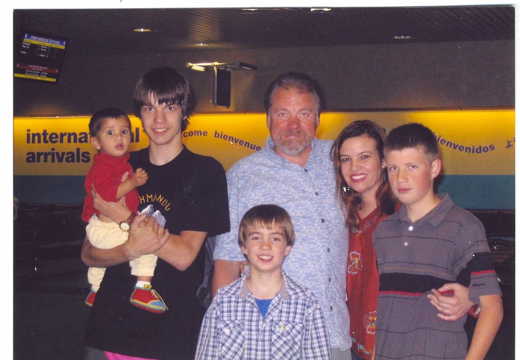 The Tuell family poses for their first photo together after Maya arrives with Michelle and Justin, who is holding her, in April 2004. Husband Chuck and sons Jeremy (right) and Jesse (center) met her for the first time that night.