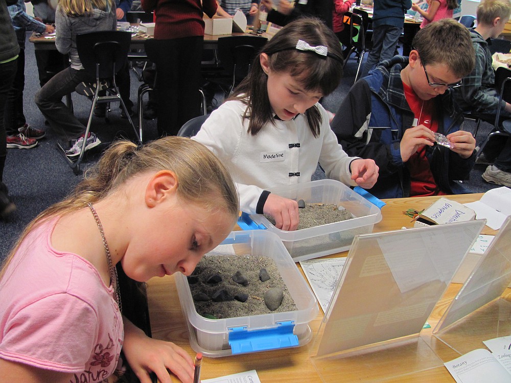 Brielle Bradshaw (left) and Madeline Wood create a relief map using stones for different landmarks.