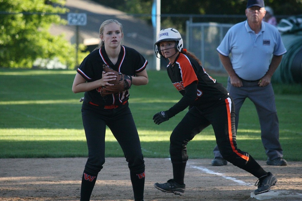 Washougal High School senior Brooke Croeni (left) keeps an eye on the plate and the Battle Ground runner leading from first in the All-Star Challenge, at Clark College.