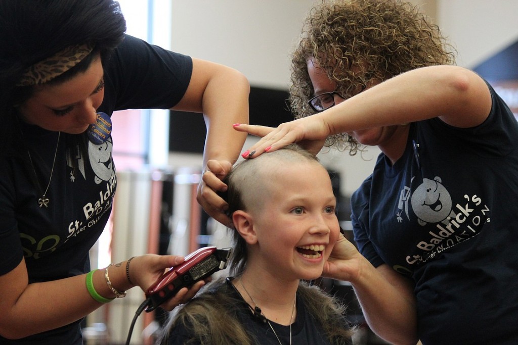 Washougal third-grader and cancer survivor Sammy Mederos reacts to getting her long locks of curly blond hair shaved off by Shelby Cummings (left) and Holly Thorpe (right) during a fundraiser for the St. Baldrick's Foundation Sunday at Washougal High School. Mederos was diagnosed with leukemia when she was in kindergarten. Now cancer-free, she and her parents, Michele and Dennis Mederos, helped organize the event. Her dad also had his head shaved.