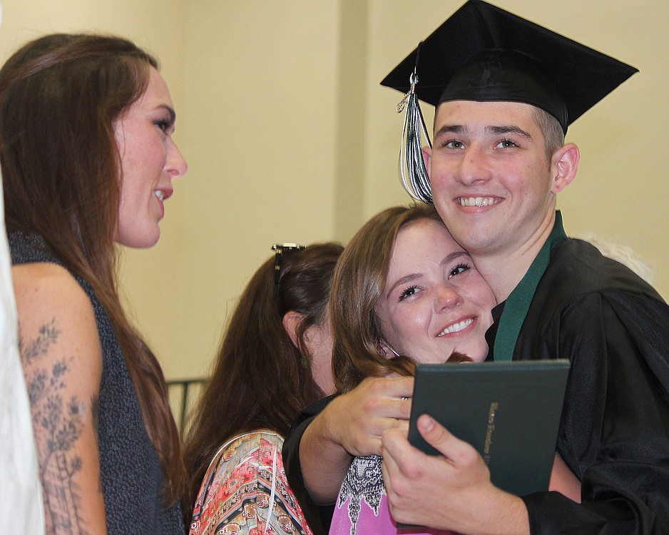 Hayes Freedom High School graduate Orion Hobson gets a hug from teacher Rachel Pierce as he makes his way through the receiving line during the graduation ceremony.