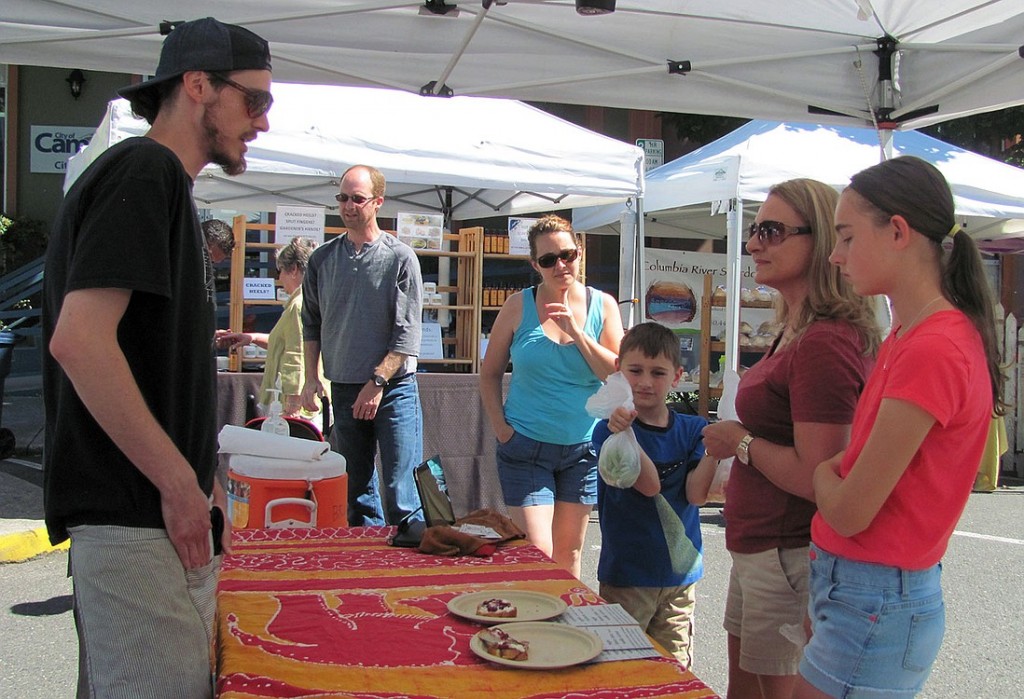 Alex Collins, co-owner of Herb N' Roots, served tastings of brioche toast with ricotta and strawberry apple rhubarb jam at the market. Herb N' Roots is a new vendor this year.