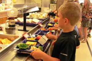 Lacamas Elementary School student Jesse Raunig has several servings of fruits and vegetables on his lunch tray. Recent federal regulations require that students take at least one-half cup of these for the lunch to count as a reimbursable meal.