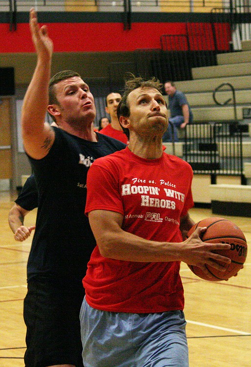 Firefighter Matt Baldwin gets by police officer Colton Price on a fast break during the Camas-Washougal Fire vs. Police charity basketball game. The fire department made a big push late in the game, but the police held on for a 65-58 victory.