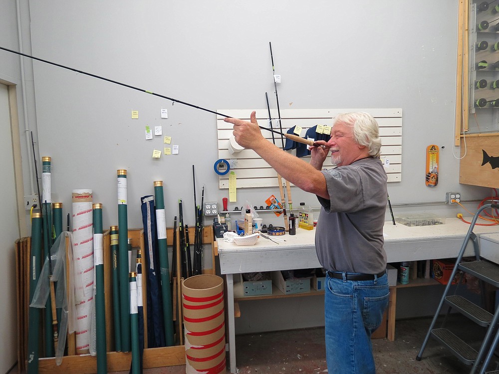 Carl Francis "Kerry" Burkheimer III smiles at the finished product of a fly rod built in his downtown Washougal shop. The company assembles and ships close to 1,500 rods a year to fishermen all over the world.