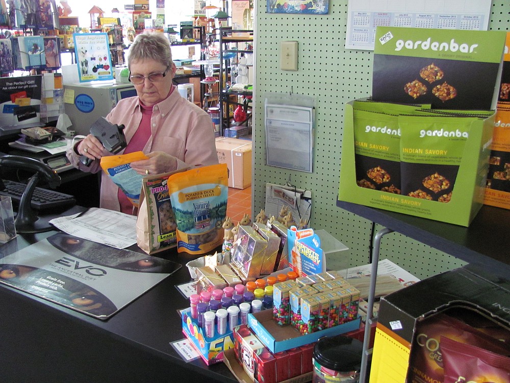 Wanda McFarlane, owner of Healthier Choices, in Washougal, enters new stock items into the point of sale system. The store benefits the community by donating dog and cat food to the West Columbia Gorge Humane Society, in Washougal.