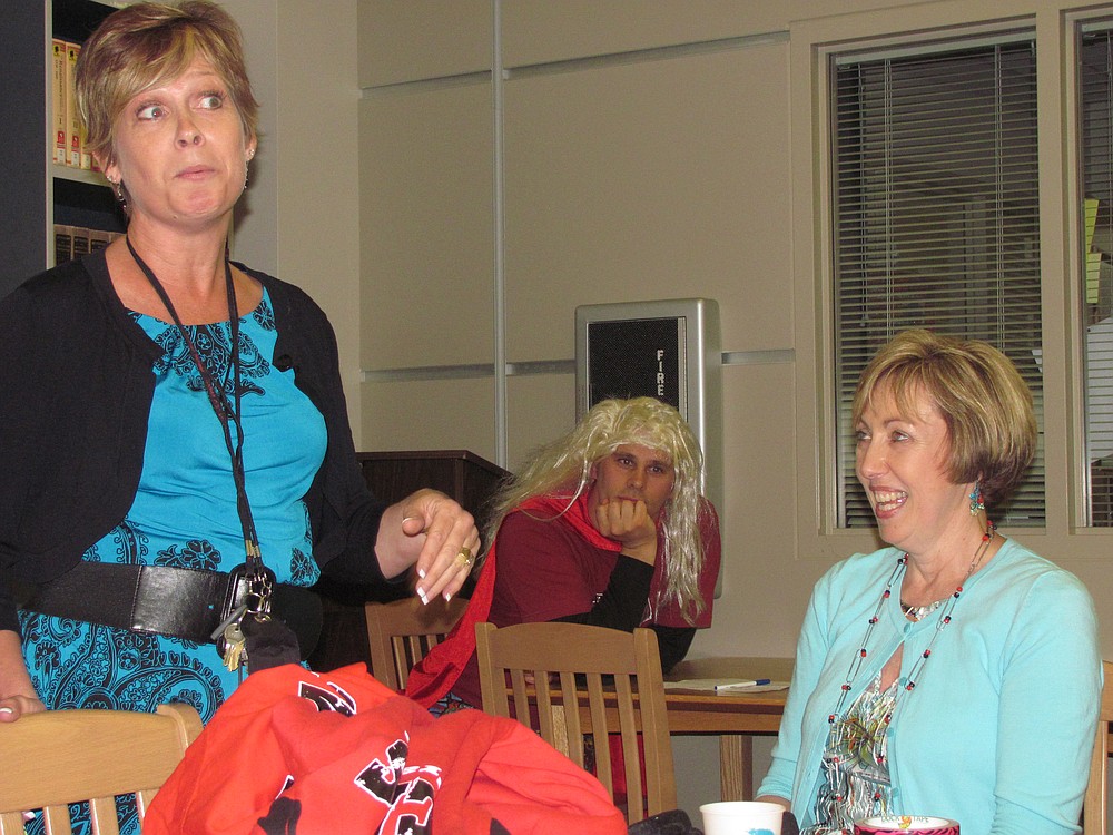 Camas High School librarian Rosemary Knapp (seated) listens to a funny story from career specialist Suzie Downs during her retirement party earlier this month. Knapp, 61, retired after 31 years with the Camas School District.