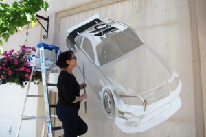 Maria Grazia Repetto measures every nook and cranny while she paints a Ford Fusion racing car made famous by NASCAR driver and Camas native Greg Biffle. This is her second painting for the Camas-Washougal "Yesterday, Today and Tomorrow" Mural Project.