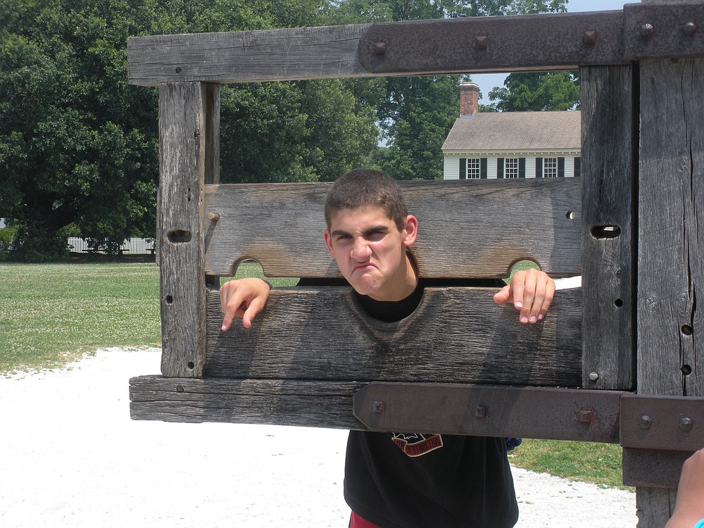 Matthew Rotundo poses in the stocks at Colonial Williamsburg.