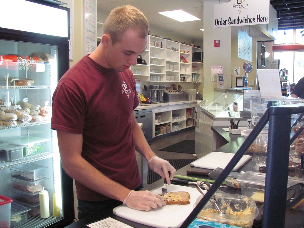 Greg Boland prepares a sandwich at Papa's Ice Cream. The 20-year-old works approximately 75 hours a week at two jobs to save for college expenses.