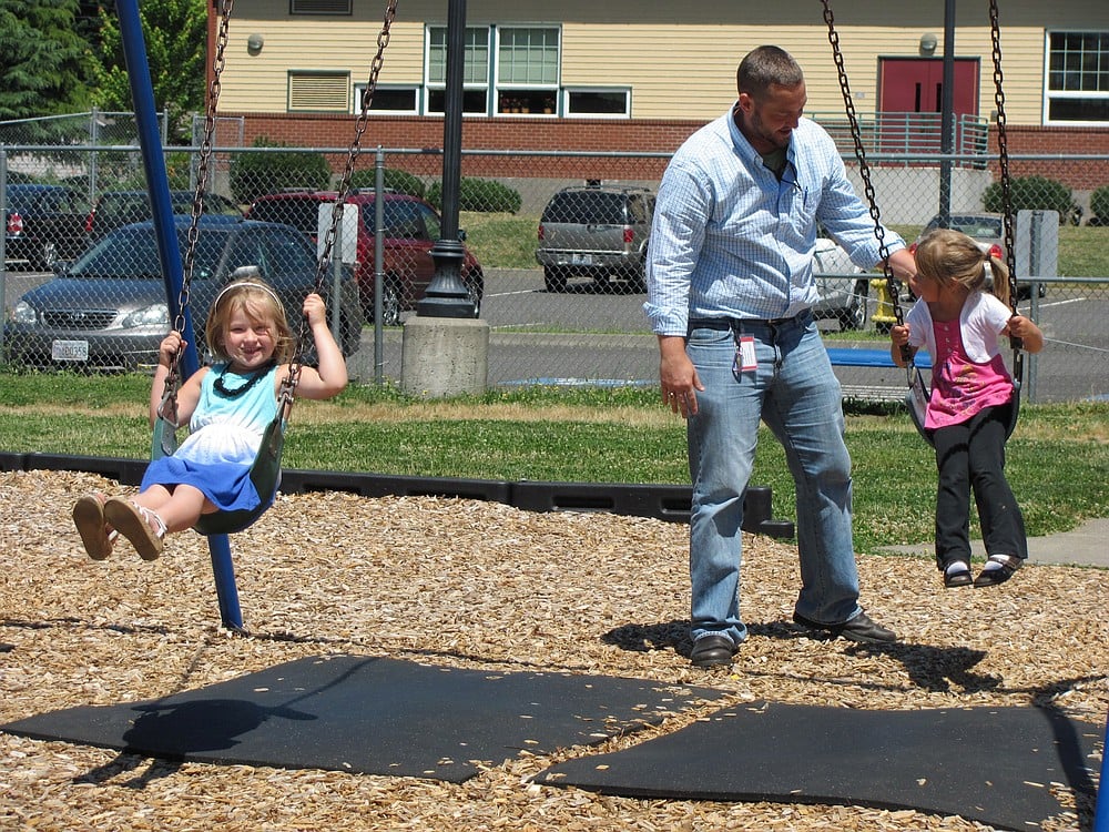 During outdoor activity time at Hathaway, everyone gets involved. David Tudor, Washougal School District curriculum director, is no exception. Here, he pushes students on the swings.