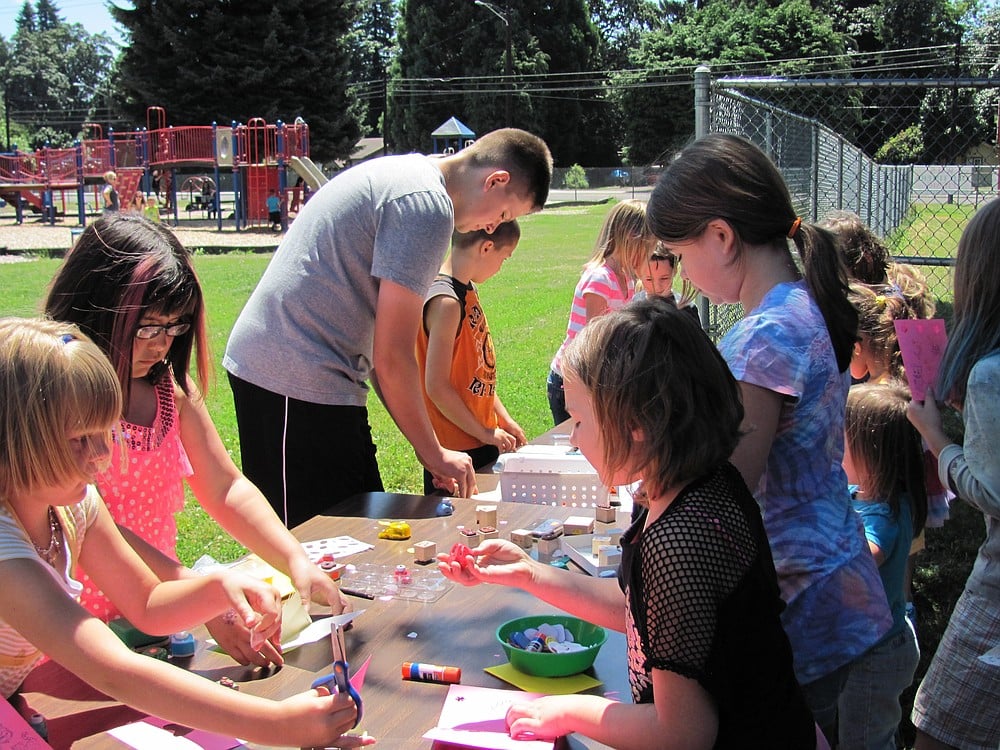 Local students enjoy craft projects in the sun with art supplies donated by a district patron.