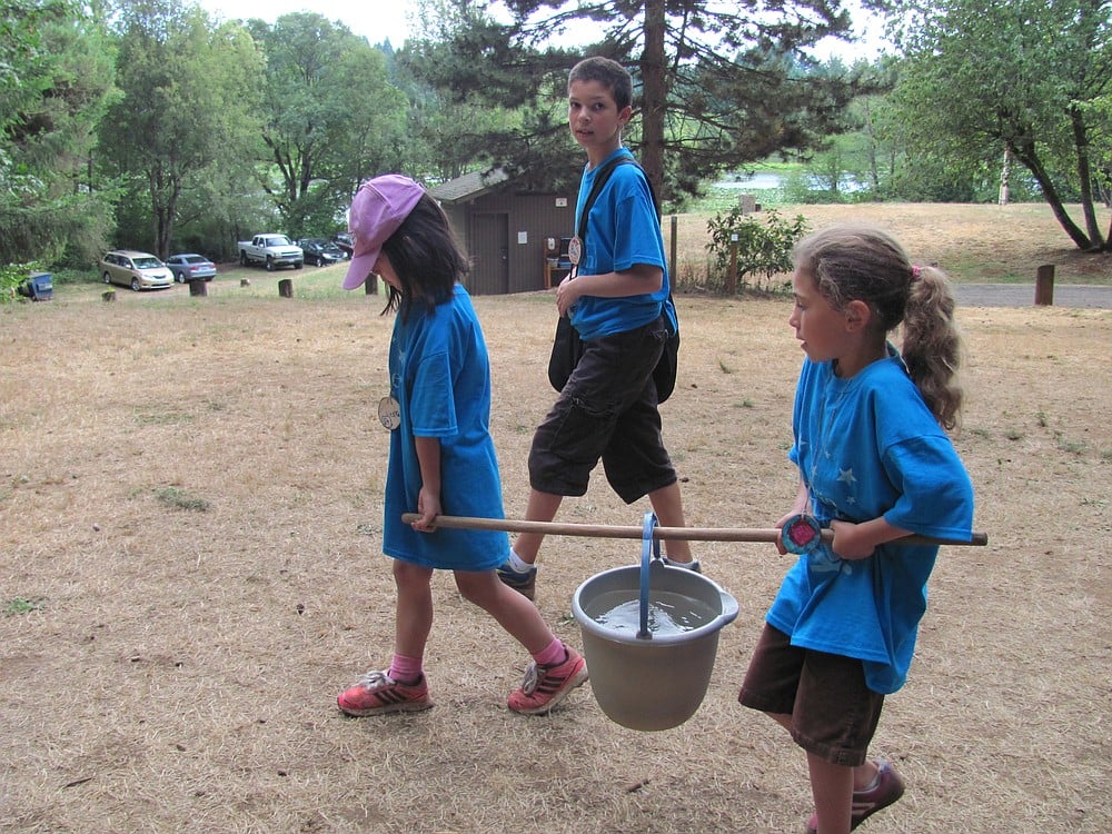Campers carry their own water from a well pump in order to cook and wash dishes.