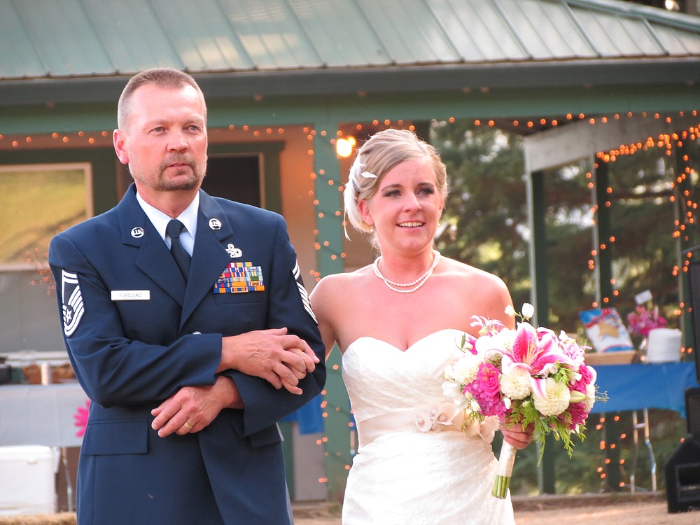 Jamie Forslund and her father, Brian,  walk down the aisle to begin her marriage ceremony to  Kory Huffman.