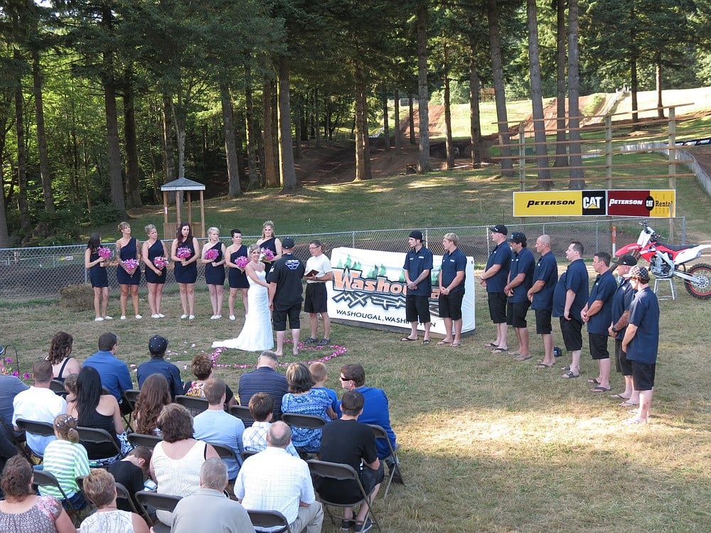 The wedding party included seven bridesmaids in black cocktail dresses and nine groomsmen in Motocross-themed attire.