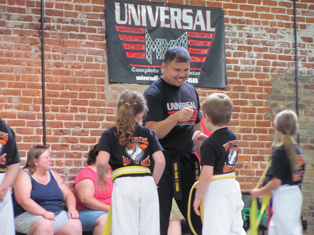 Universal MMA co-owner Frank Coones congratulates students after class.