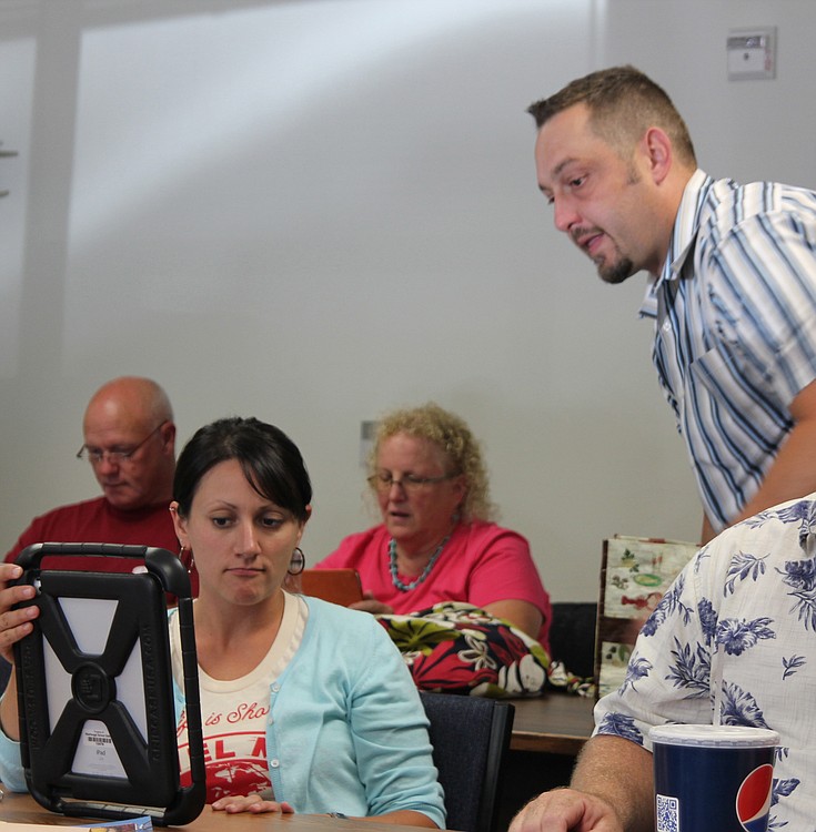 Washougal School District Curriculum Director David Tudor assists Hathaway Elementary School fifth-grade teacher Erin Hayes during an iPad training session.