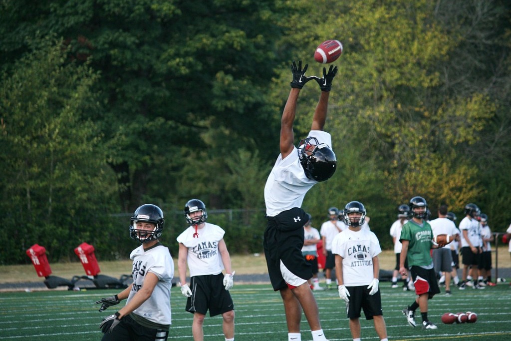 Camas High School senior James Price reaches up for the football during Thursday's twilight practice at Cardon Field.