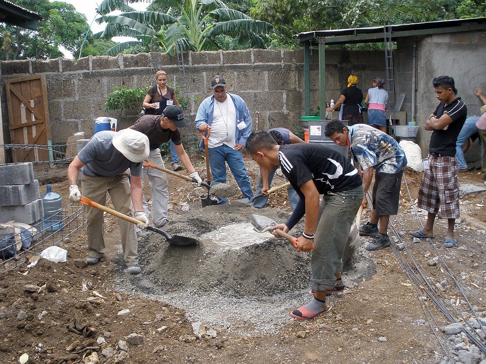 Side-by-side, members of the Gateway Community Church Nicaragua Mission Team and  residents of Tipitapa mix cement for the expansion of a church. Some of the same team members helped build the original church nine years ago.