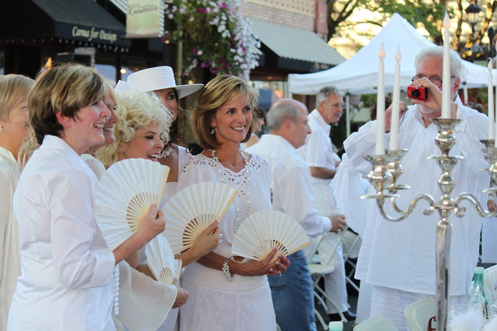 More than 150 people attended the "Camas in White, Dinner on Fourth Avenue" event on Saturday evening in downtown. Attendees dressed in white outfits and dined at tables decorated in white color themes. This group of friends, many of whom are neighbors in the Lacamas Shores area, pose for pictures before dinner begins. The event was a fundraiser for the Camas-Washougal Mural Project. Through an auction of five art pieces, approximately $2,215 was raised, including a $1,400 winning bid by Capstone Technology Corp. for a  painting of the Camas mill by local artist Maria Grazia Repetto. View additional photos from the event at www.camaspostrecord.com.