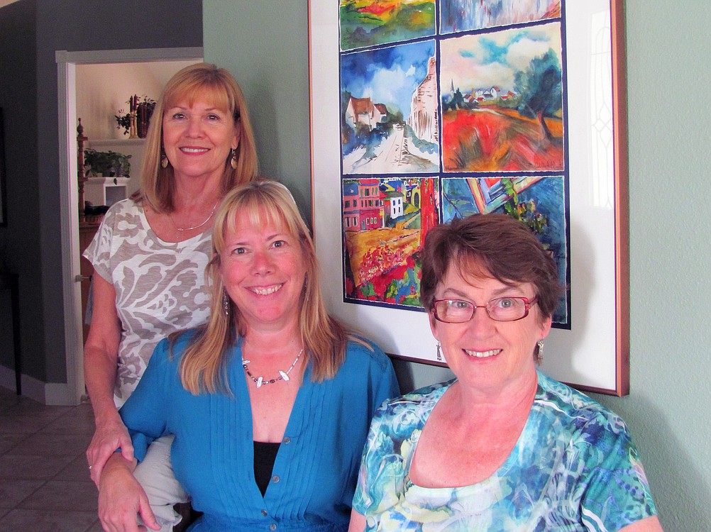 Kathy Sork, AnnaMarie "Suzy" Clement and Linda McCulloch (left to right) pose by a six-paneled group watercolor they helped create. The other artists who painted panels were Julianne Schreiner, Carolyn Gunderson and Judith Sanders-Wood.