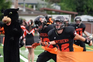 Washougal football players burst through an orange ribbon to celebrate their new turf field at Fishback Stadium. The Panthers defeated Hudson's Bay 35-0 Friday.