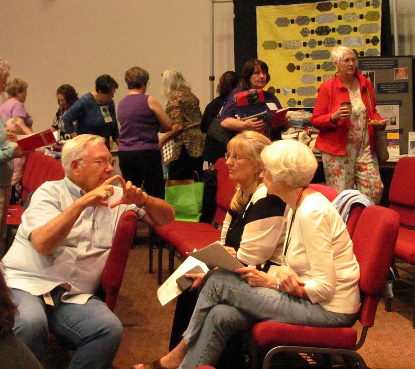 Members of the quilting guild chat with an audio technician with the Vancouver Church of Christ before the meeting begins.