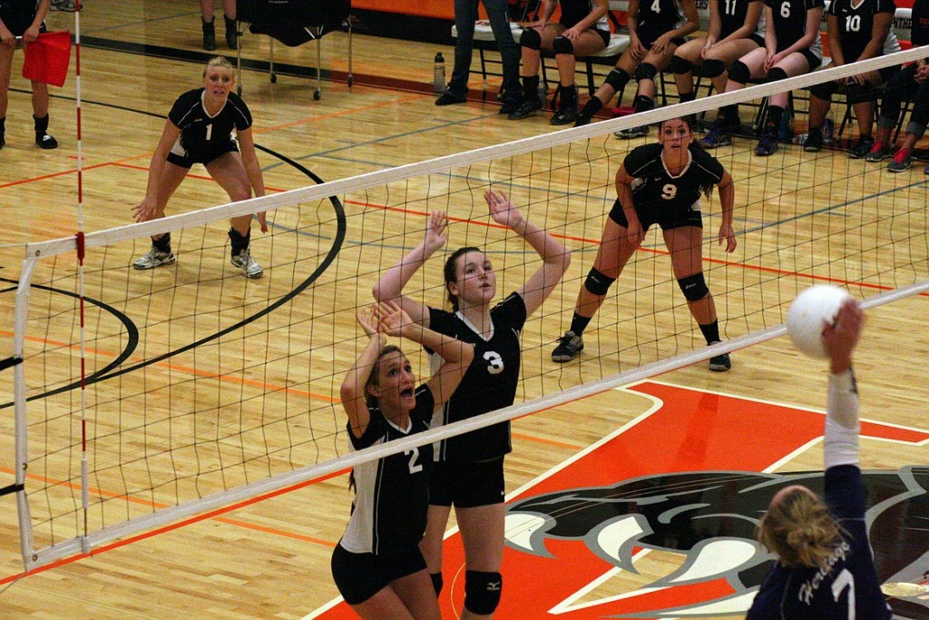 Washougal volleyball players Paige Bentley (2) and Carly Morris (3) reach up to protect the net. The Panthers played on their new floor for the first time Sept. 10. They defeated Fort Vancouver on the road Thursday and at home Monday.