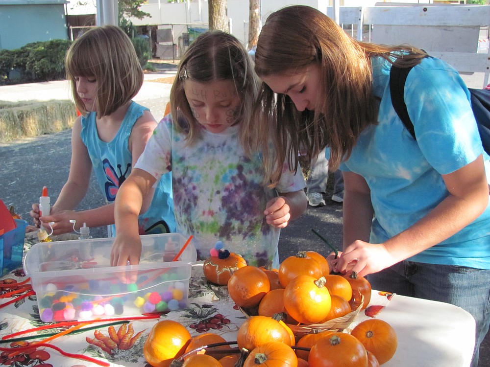 Children participate in pumpkin decorating during the Camas Farmer's Market Harvest Festival.