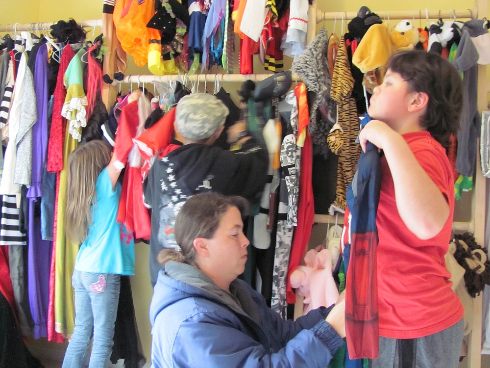 Heather Perkins of Camas checks a Captain America costume for fit on her son, Qwynn, while daughter Maddizynn and friend Jonathan Vanhorn search the racks for creative ideas.