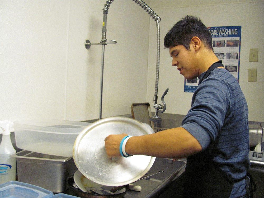 Josiah Schmid washes dishes at K'Syrah restaurant in downtown Camas. He is a student in the CHS life skills  vocational development program.