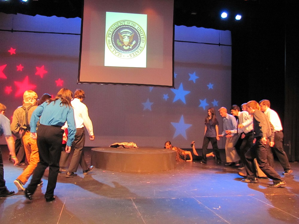Cast members rush to grab the presidential coat during a scene from "44 Plays for 44 Presidents."