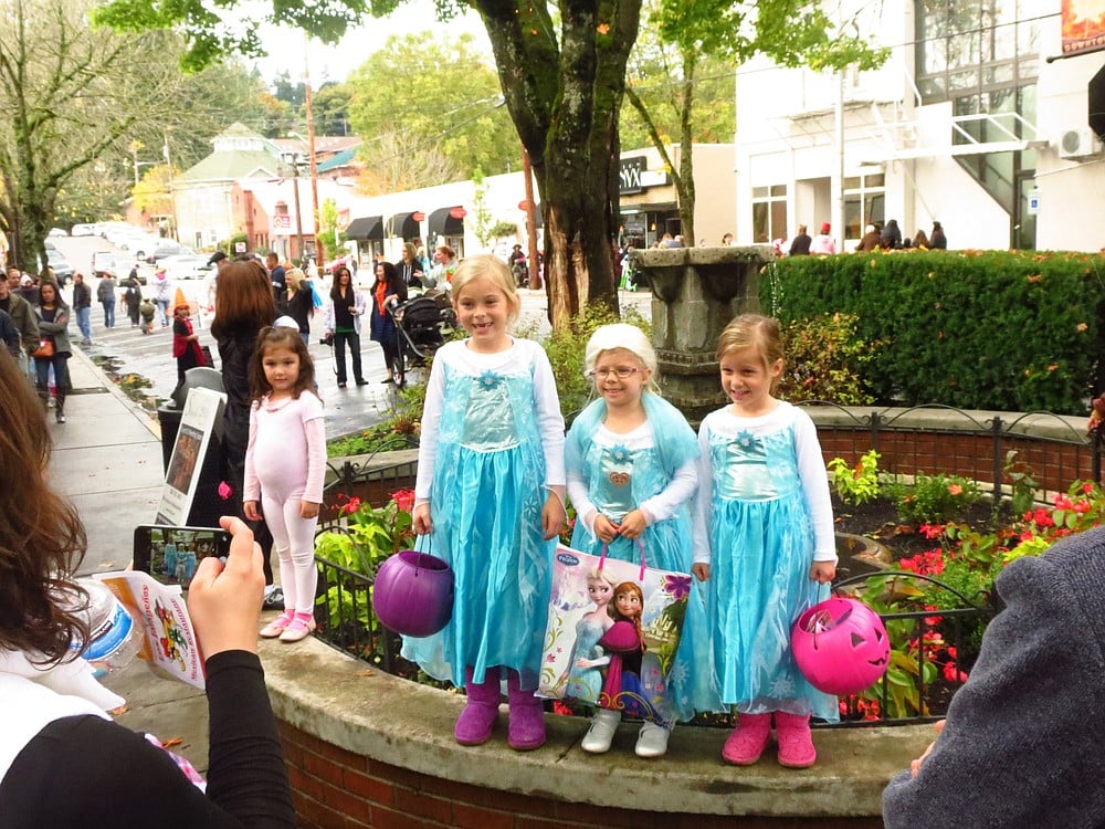 Three little girls dressed as Elsa the Snow Queen from the popular Disney movie "Frozen" pose together by the Cedar Street fountain.