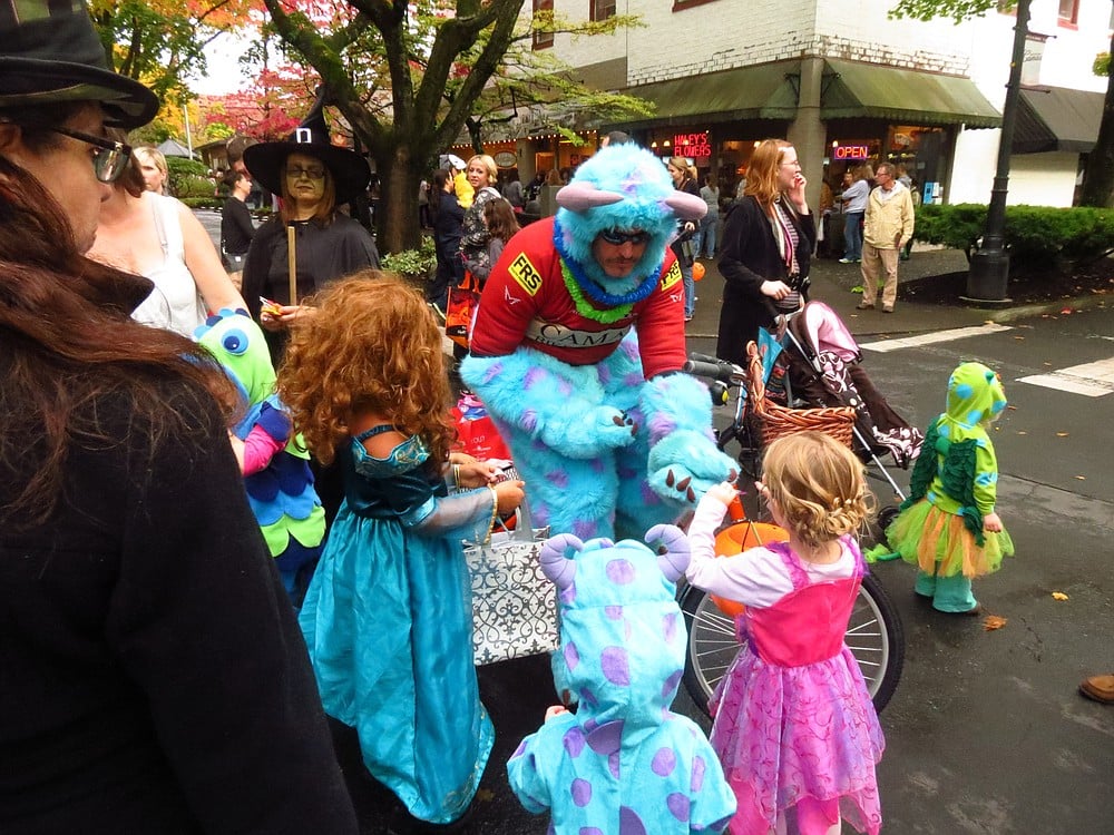 Camas Bike & Sport co-owner Ed Fischer gives candy to children during Boo Bash Wednesday.